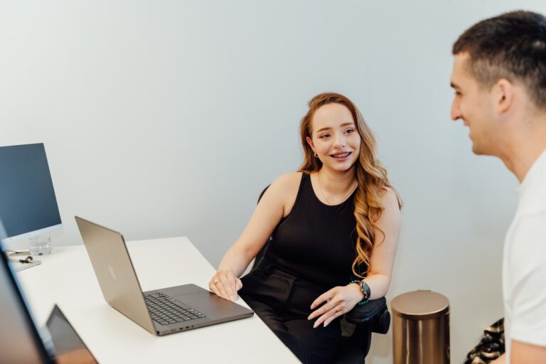 Colleagues talking through work on a laptop