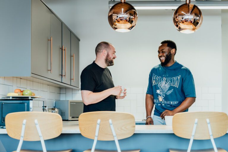 Team hanging out side by side in the kitchen
