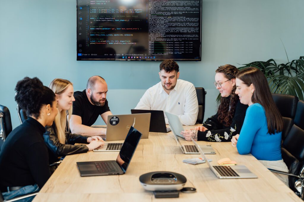 6 corecom colleagues working together on python coding