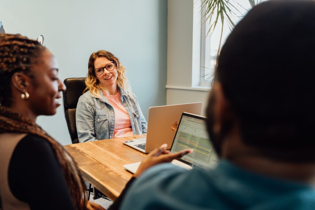Avril in a denim shirt smiling at Shantelle who has her laptop open and is explaining something