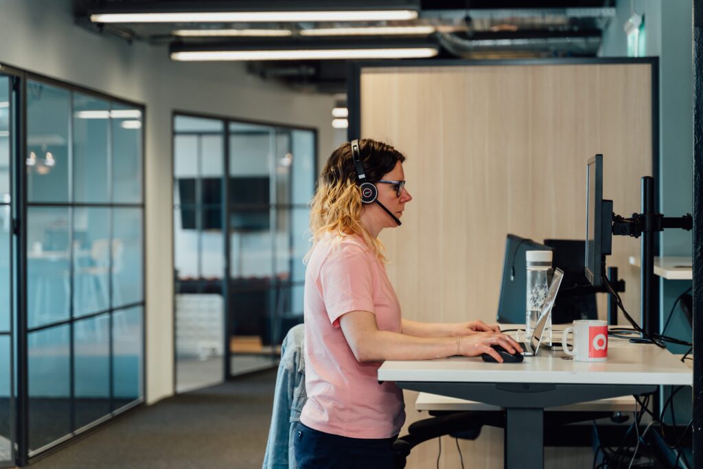 Avril at a standing desk with headphones on working