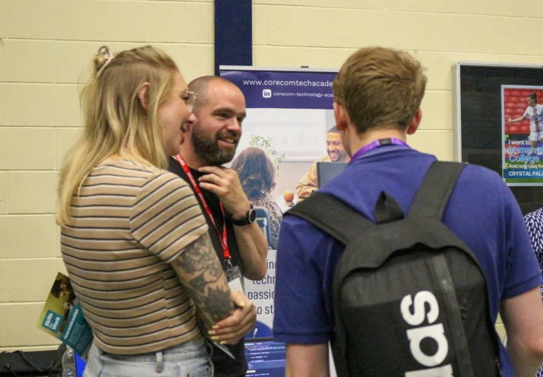 CoreCom employees speaking to someone at a open day fair