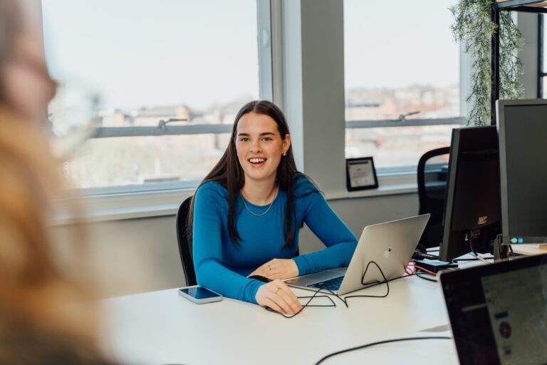 Maddie at her work laptop smilling