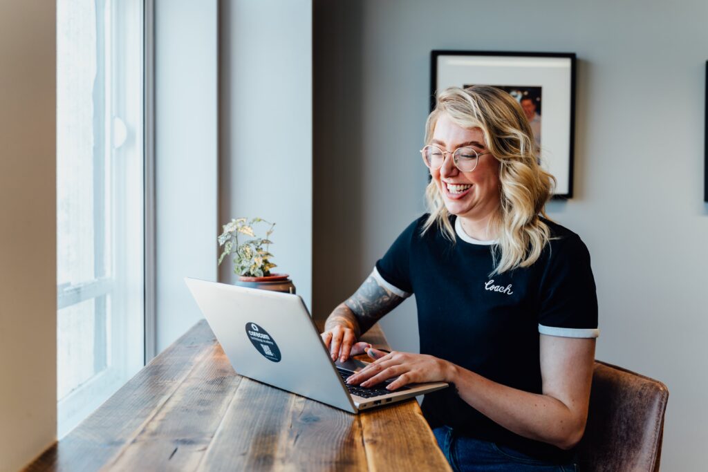 Rachel at desk smiling at laptop