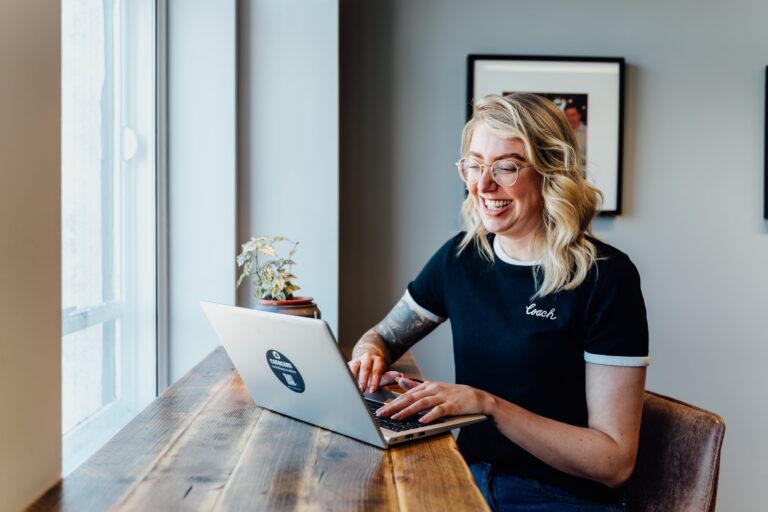 Rachel at desk smiling at laptop